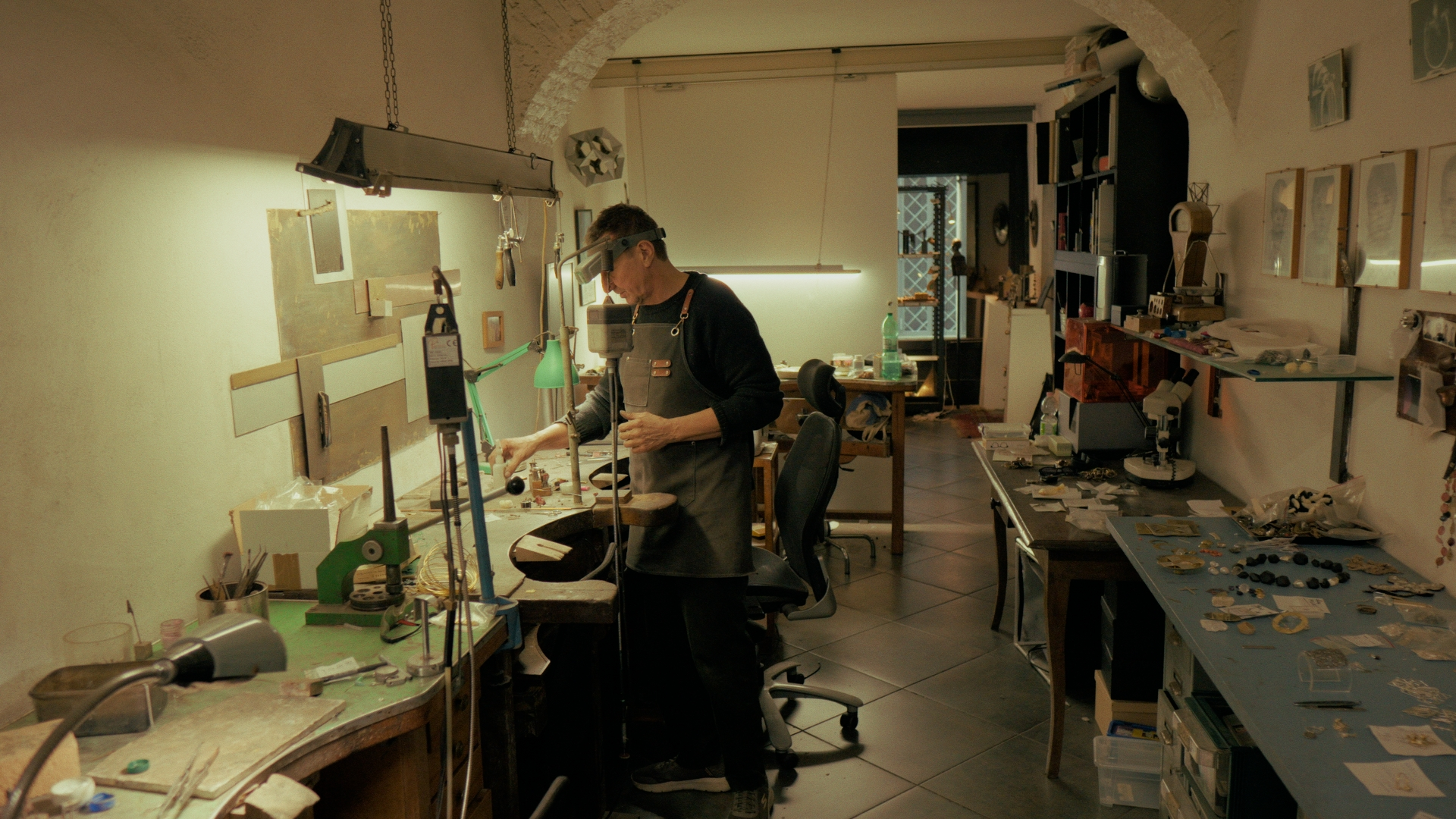 Person working in a cluttered workshop with tools and equipment.